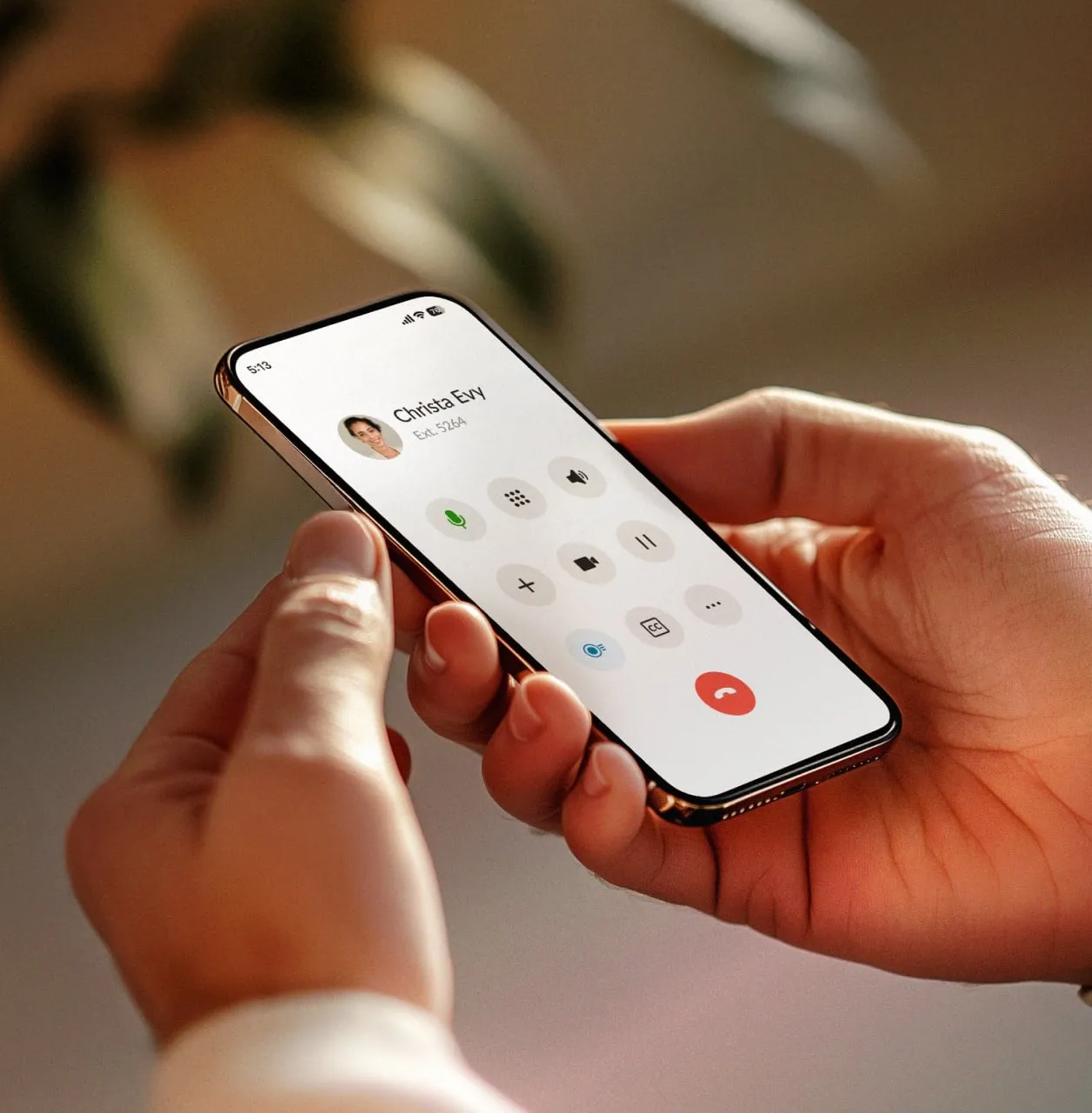 A close-up of a person holding a smartphone using a professional mobile VoIP calling app interface with Christa Evy on the screen.