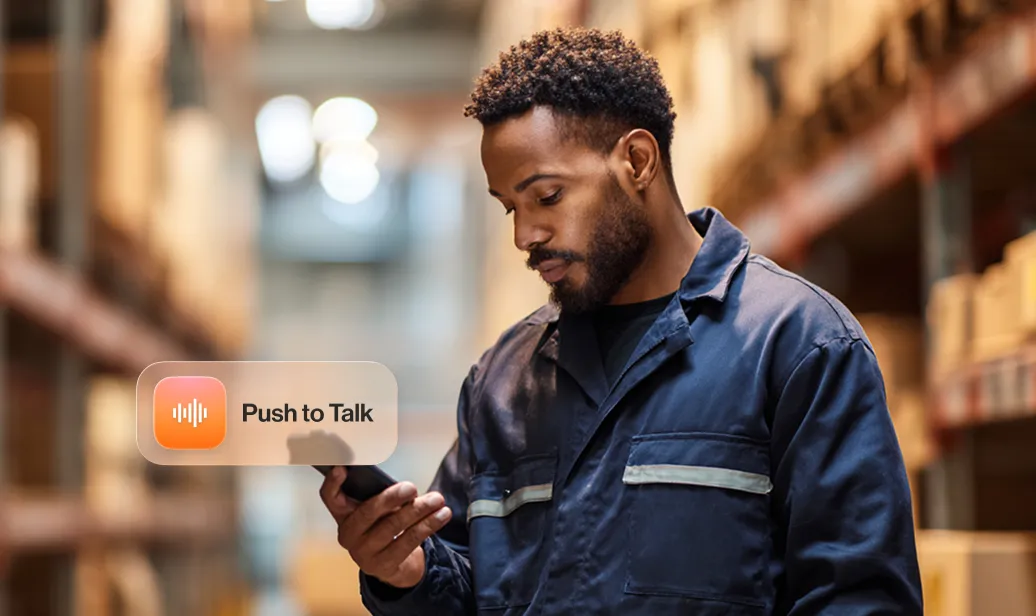 Warehouse worker using the Push to Talk feature on a smartphone, enhancing communication and efficiency.