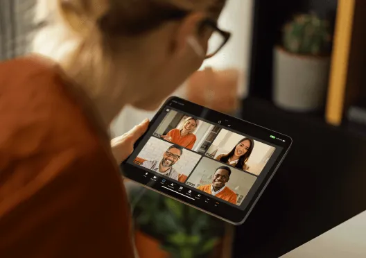 A woman using her tablet for a virtual video meeting with her peers