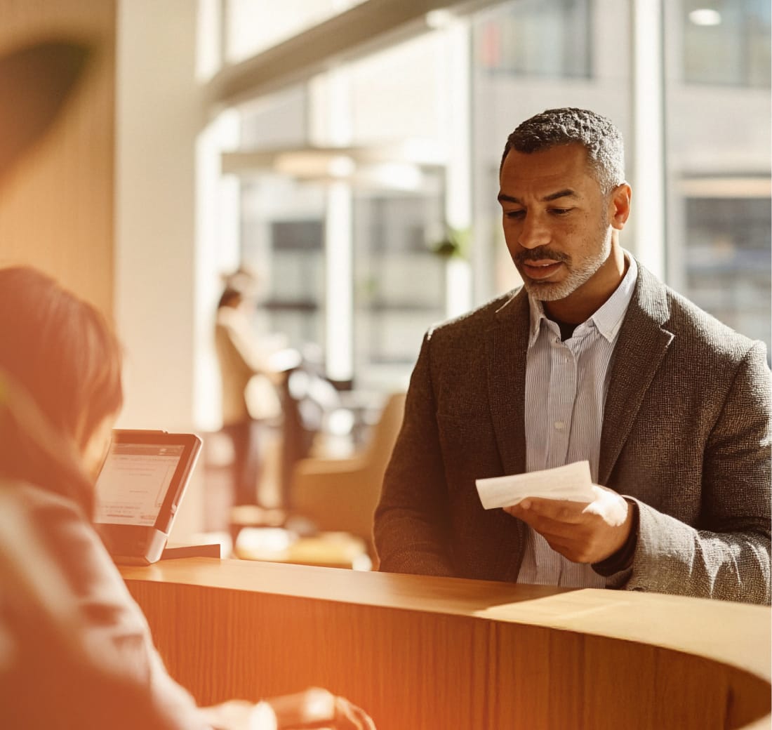A bank customer depositing a check with support from a bank teller.