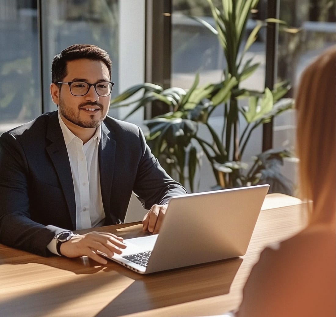A lawyer with a laptop talking to a female client across the table