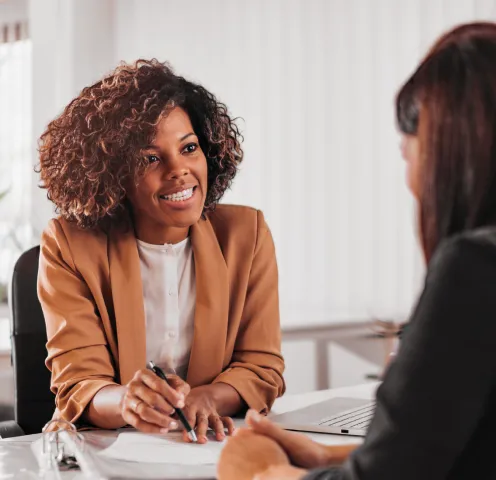 Two female colleagues talking with each other about the RingCX Service Privacy datasheet