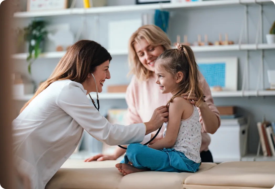 A healthcare professional listens to a child's heartbeat with a stethoscope.